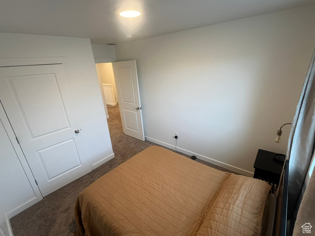 Bedroom featuring dark colored carpet