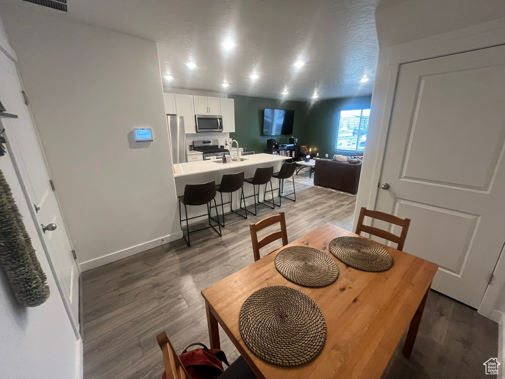 Dining space with dark hardwood / wood-style flooring