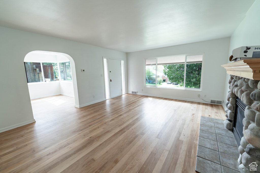 Unfurnished living room with light hardwood / wood-style flooring and a fireplace