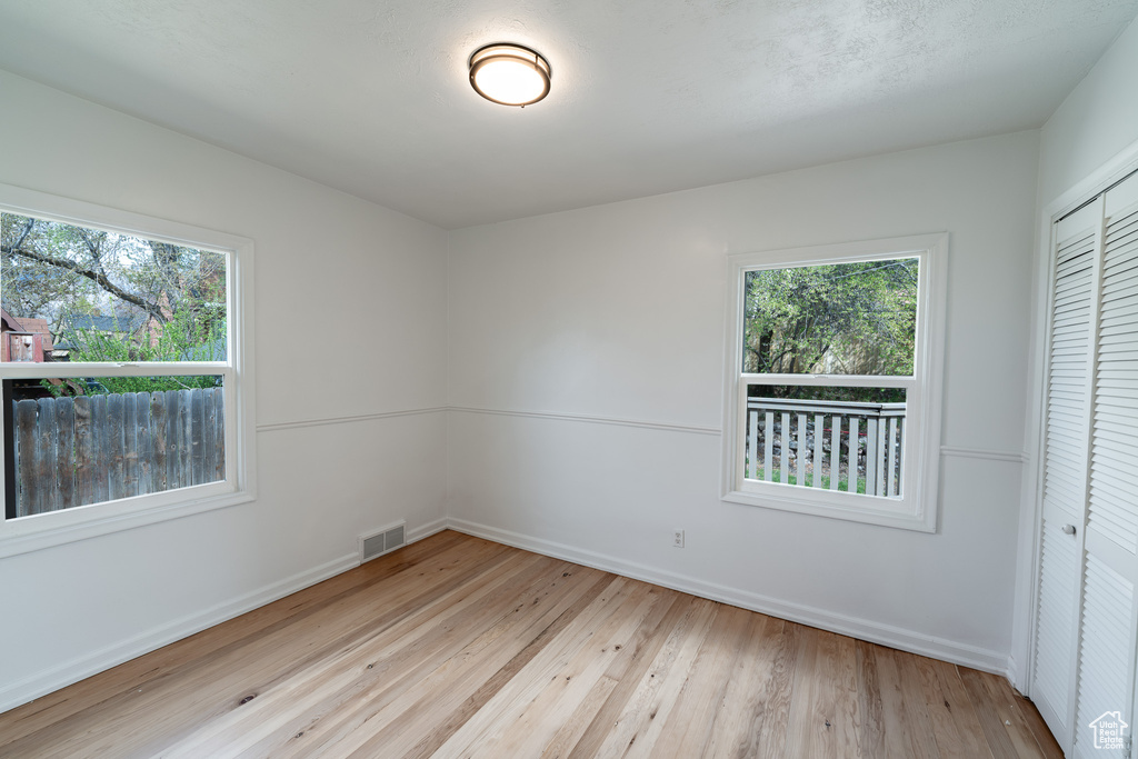 Unfurnished room featuring light hardwood / wood-style flooring and a wealth of natural light