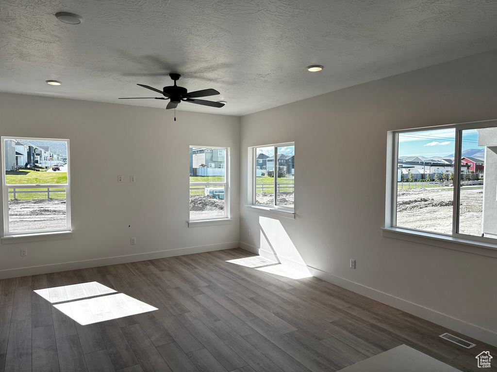 Unfurnished room with ceiling fan and hardwood / wood-style flooring