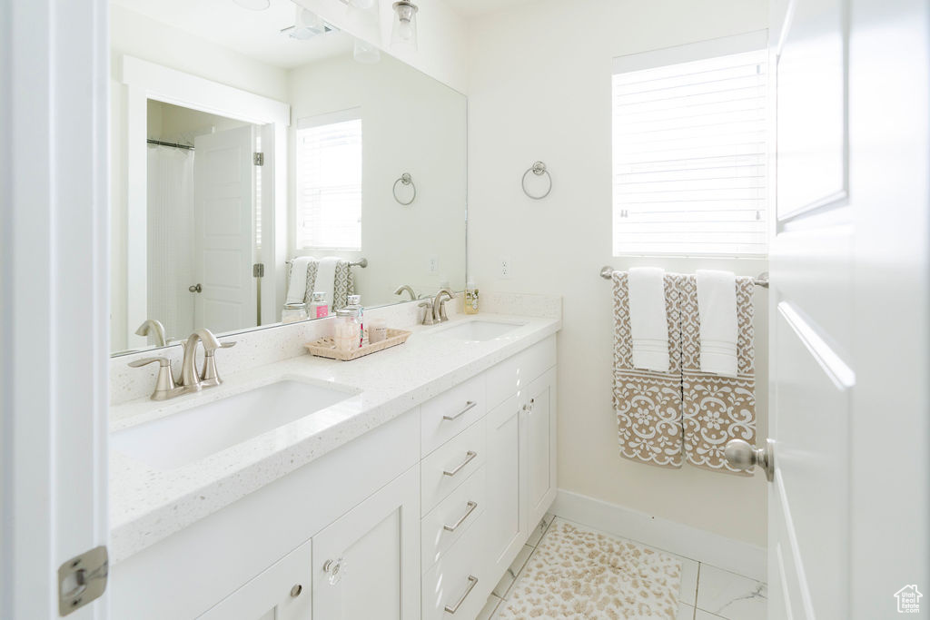 Bathroom with tile flooring and double sink vanity