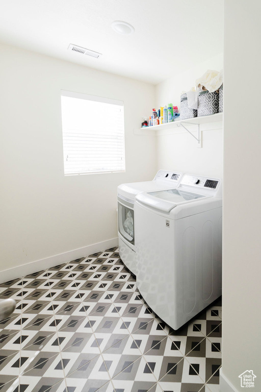 Laundry room with tile floors and washing machine and clothes dryer