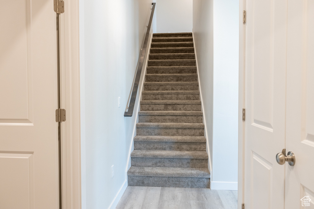 Stairway with light hardwood / wood-style flooring