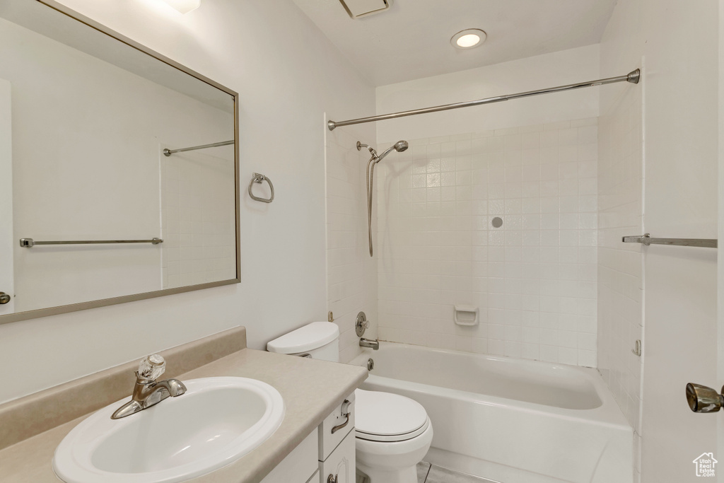 Full bathroom featuring toilet, tile floors, tiled shower / bath combo, and large vanity