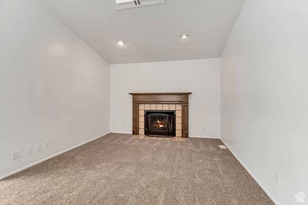 Unfurnished living room with light carpet and a fireplace