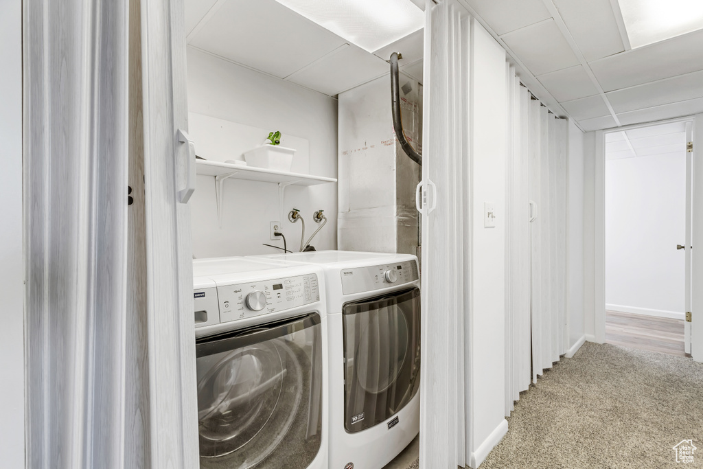 Washroom with light colored carpet and washer and clothes dryer