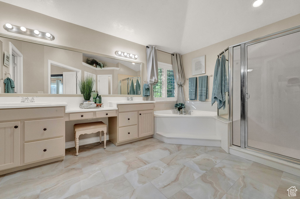 Bathroom with tile flooring, dual sinks, oversized vanity, and shower with separate bathtub