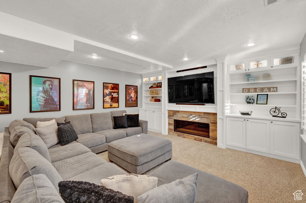 Carpeted living room featuring a textured ceiling and built in shelves