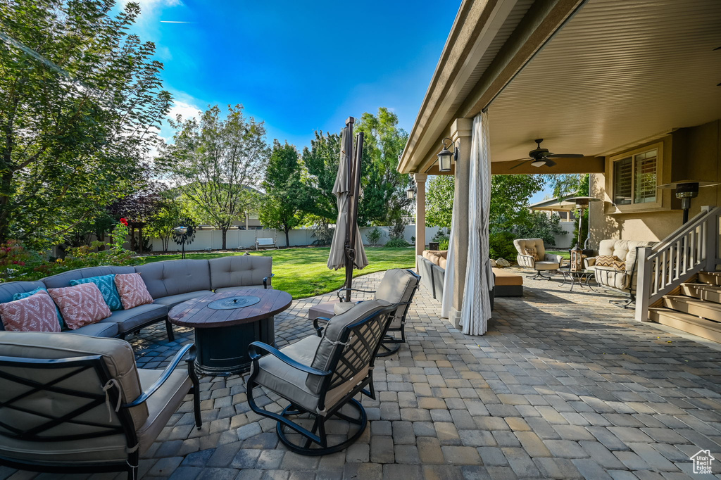 View of patio with an outdoor living space with a fire pit and ceiling fan