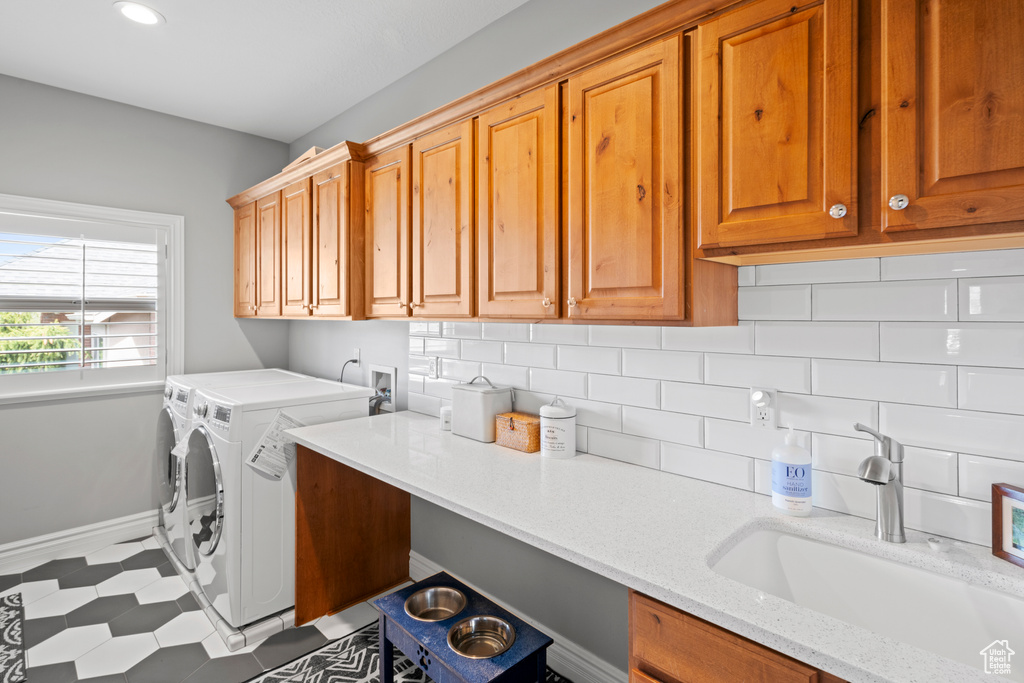 Laundry room featuring cabinets, washer and dryer, washer hookup, sink, and light tile floors