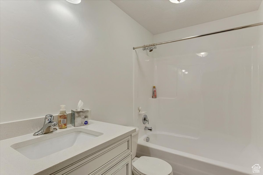 Full bathroom with bathtub / shower combination, vanity, and toilet