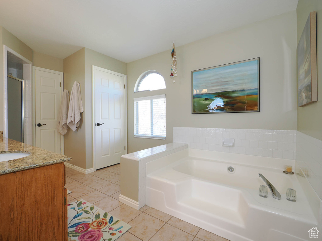 Bathroom featuring a bathtub, vanity, and tile flooring