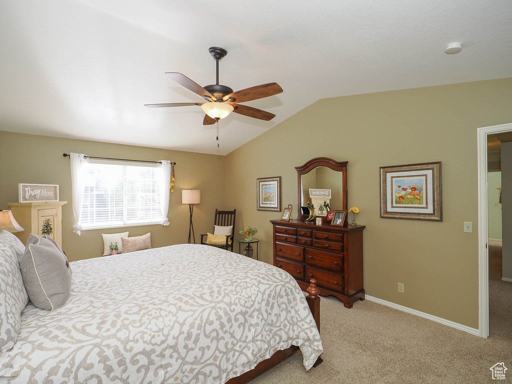 Bedroom featuring light colored carpet, ceiling fan, and vaulted ceiling