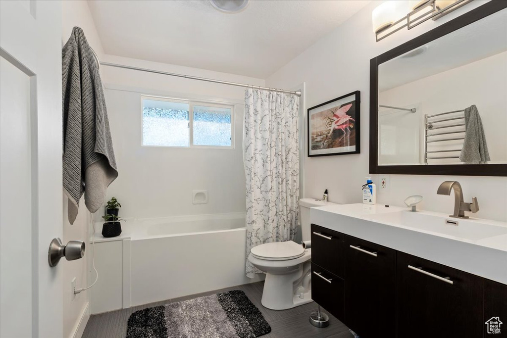 Full bathroom featuring shower / tub combo, toilet, and oversized vanity