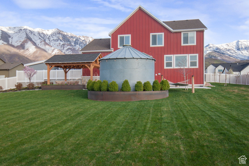 Rear view of house featuring a mountain view, a gazebo, and a yard