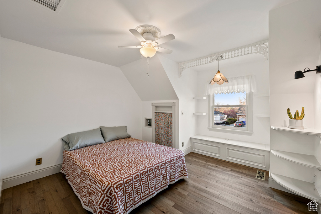 Bedroom with ceiling fan, vaulted ceiling, and light wood-type flooring