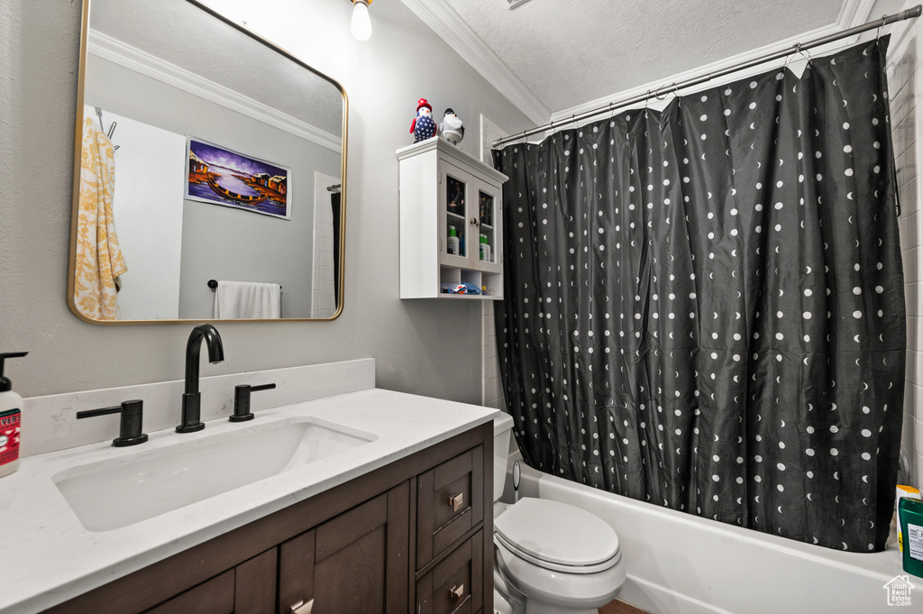 Full bathroom with a textured ceiling, toilet, ornamental molding, vanity, and shower / bathtub combination with curtain