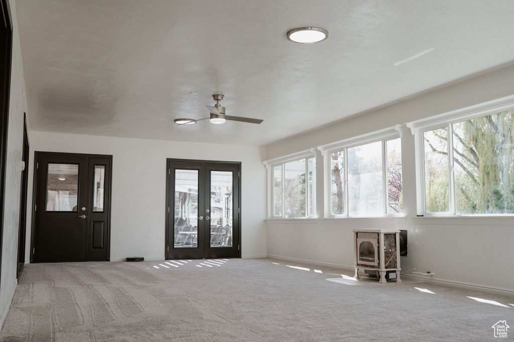 Interior space with light carpet, ceiling fan, and french doors
