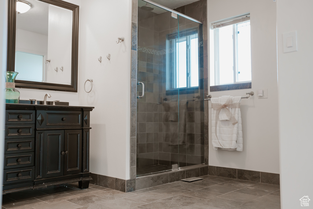 Bathroom featuring an enclosed shower, oversized vanity, and tile floors
