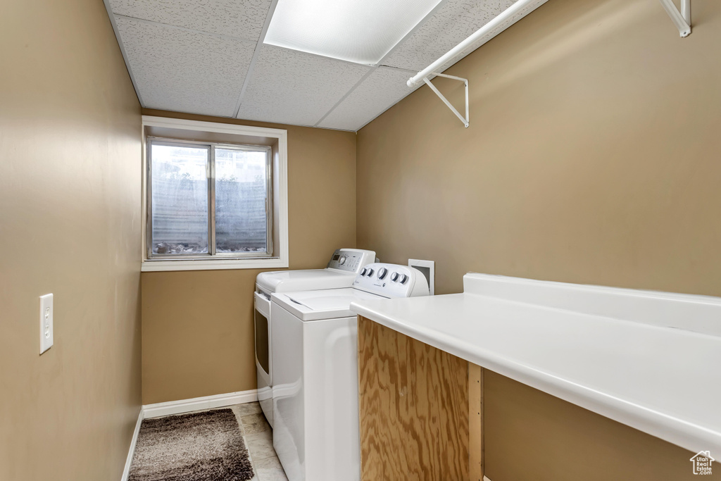Washroom featuring light tile floors, hookup for a washing machine, and washer and dryer