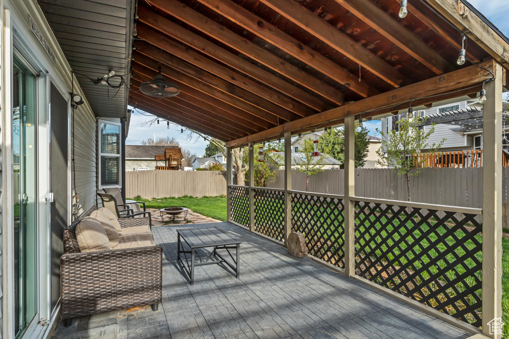 Wooden deck featuring a patio area, ceiling fan, and a lawn