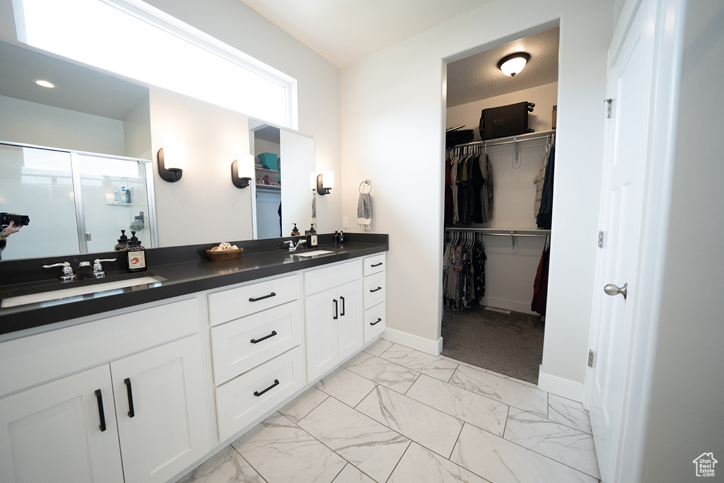 Bathroom with dual bowl vanity, a healthy amount of sunlight, and tile flooring