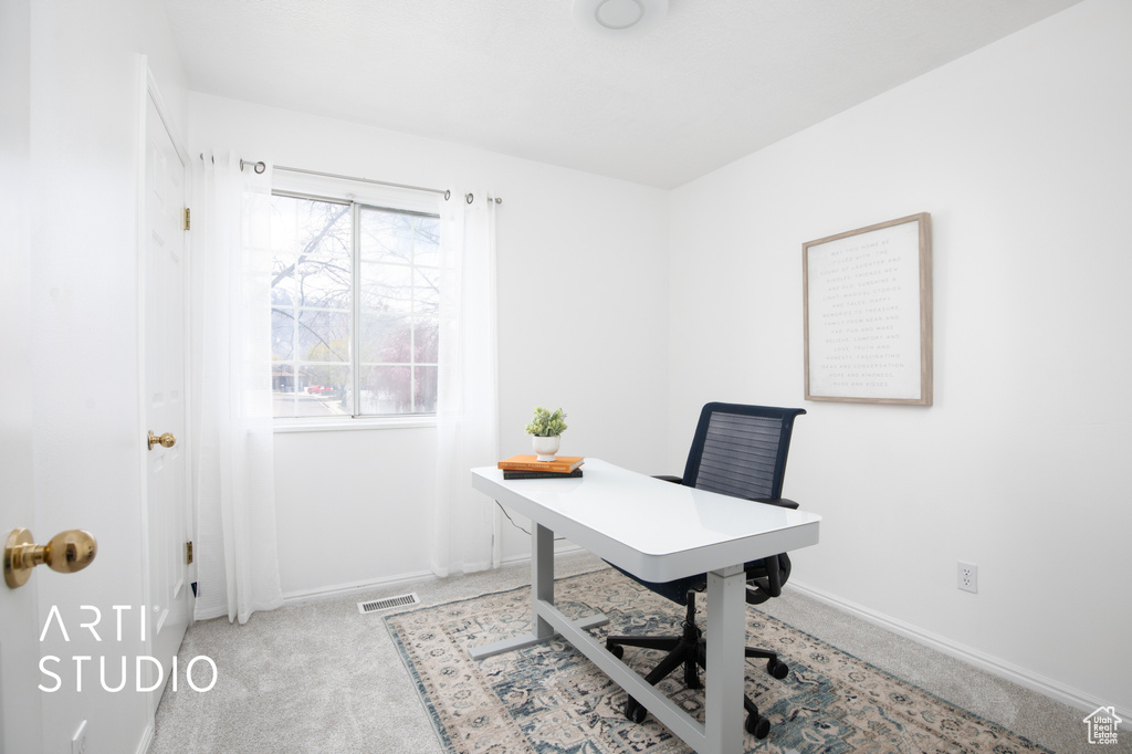 Office space with a healthy amount of sunlight and light carpet