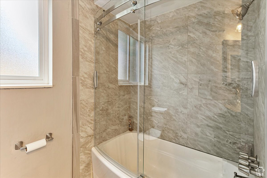 Bathroom with combined bath / shower with glass door