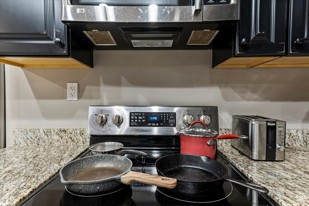 Kitchen featuring light stone countertops and stainless steel electric range