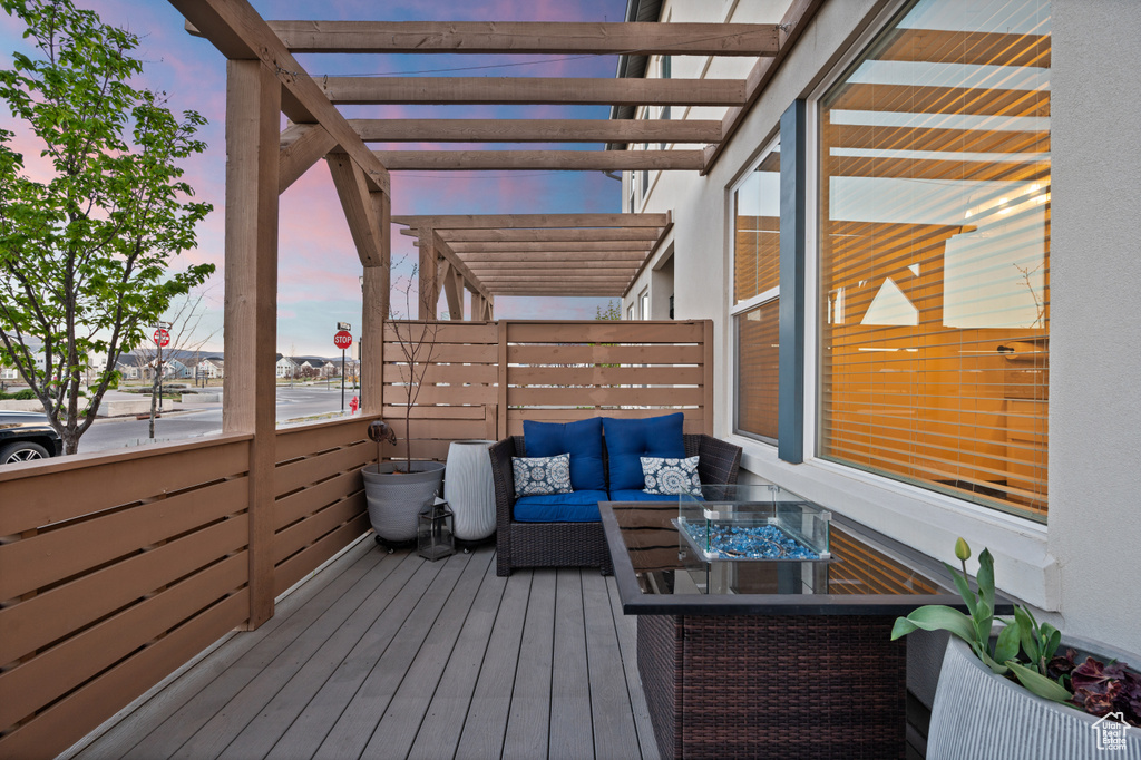 Deck at dusk with a pergola and outdoor lounge area