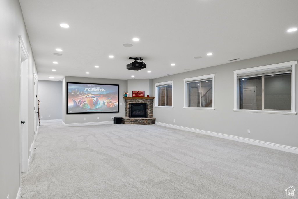 Carpeted home theater featuring a fireplace
