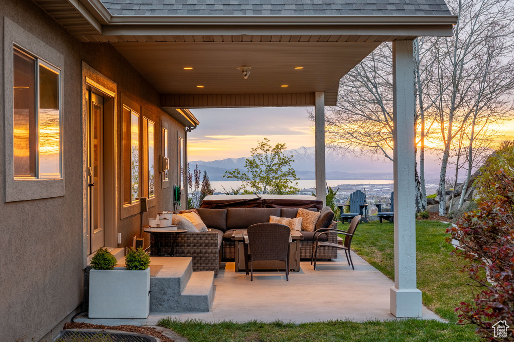Patio terrace at dusk featuring a mountain view and an outdoor hangout area