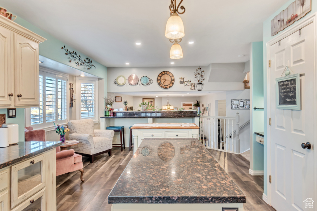 Kitchen featuring a kitchen island, decorative light fixtures, and dark hardwood / wood-style floors