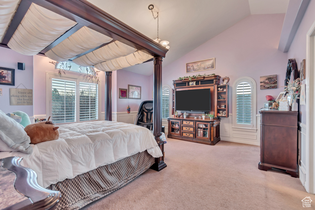 Bedroom with light colored carpet and vaulted ceiling