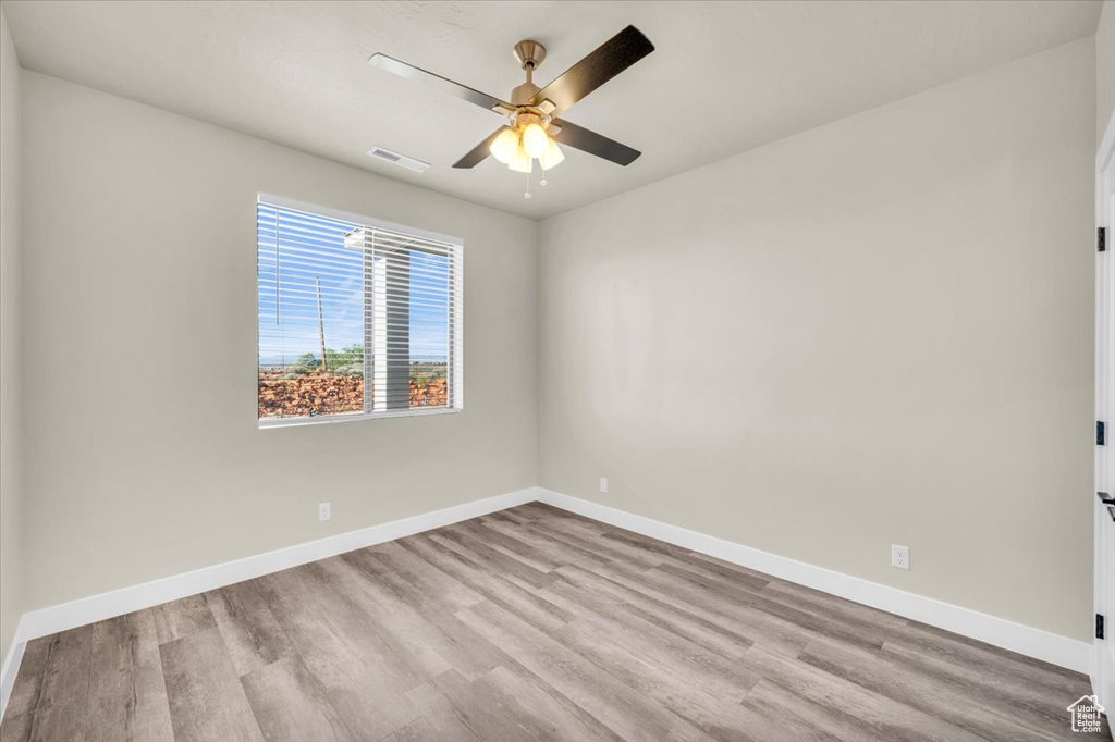Unfurnished room featuring ceiling fan and light wood-type flooring