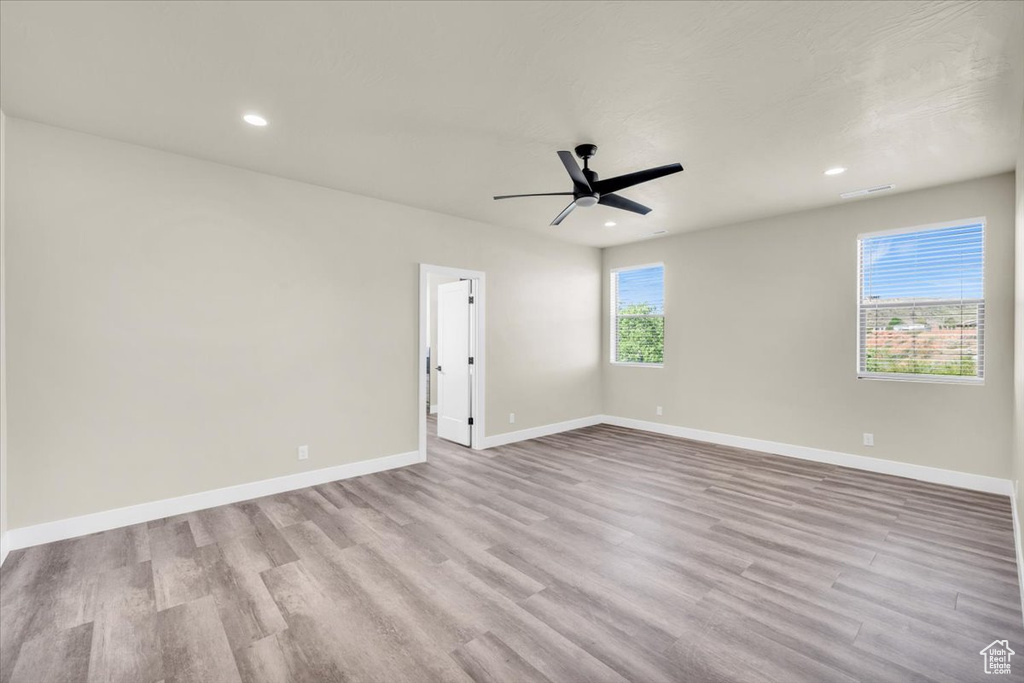 Unfurnished room with a wealth of natural light, light hardwood / wood-style flooring, and ceiling fan