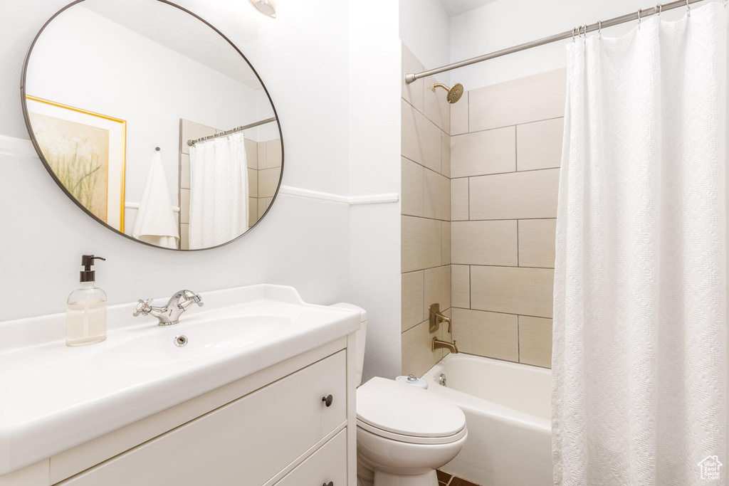 Full bathroom with vanity with extensive cabinet space, shower / tub combo, and toilet