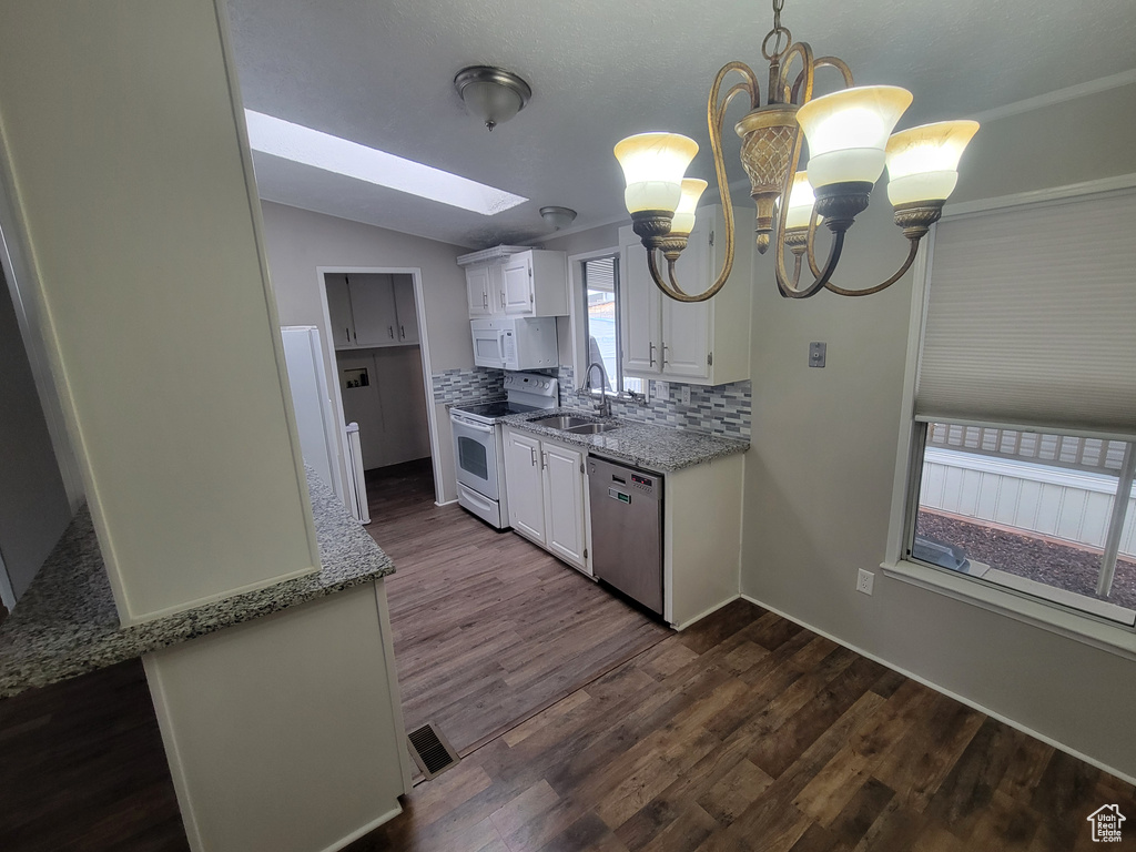 Kitchen with white cabinets, white appliances, tasteful backsplash, decorative light fixtures, and dark hardwood / wood-style floors