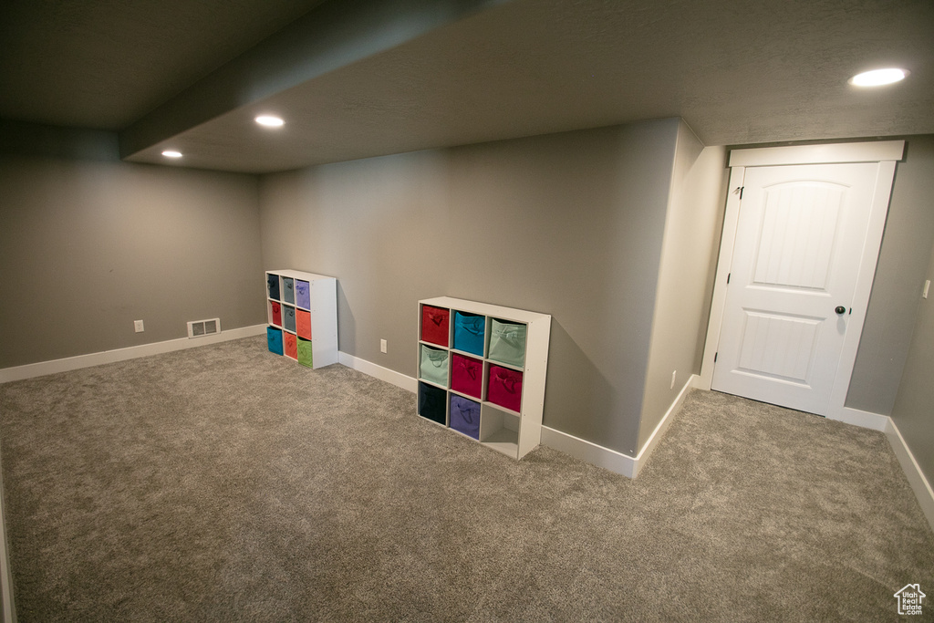 Rec room with a textured ceiling and dark colored carpet