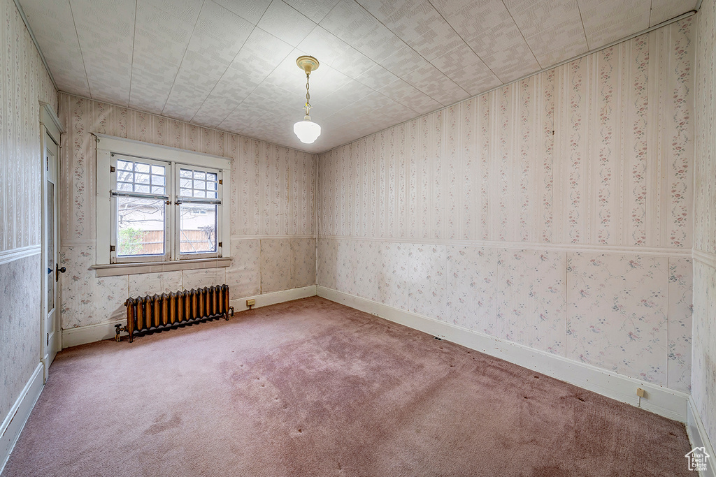 Carpeted spare room with radiator
