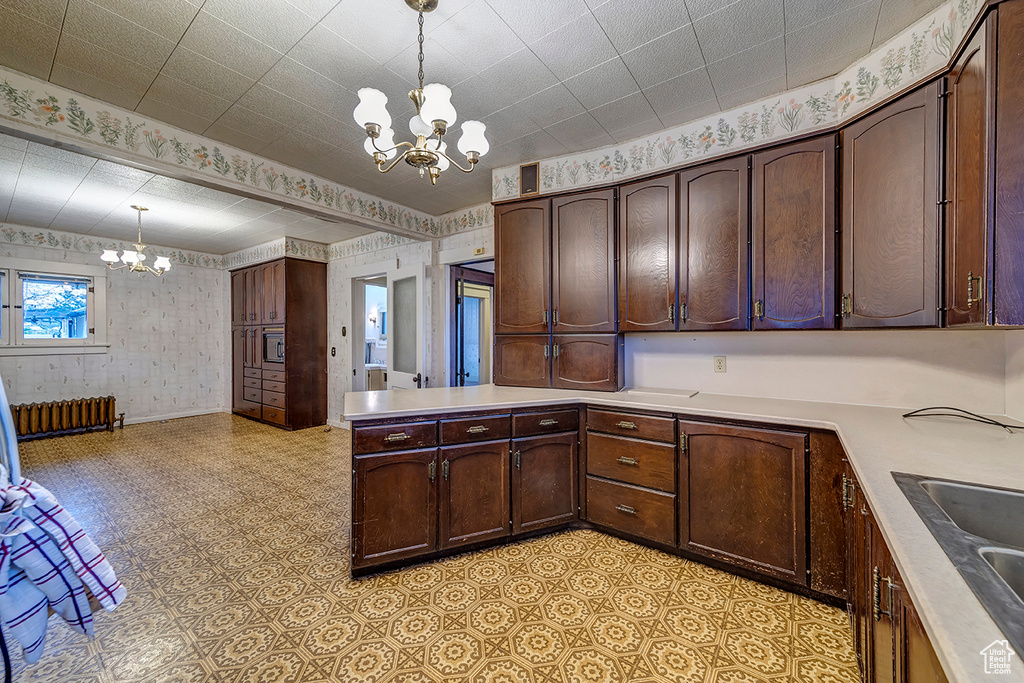 Kitchen with radiator, light tile flooring, a chandelier, and decorative light fixtures