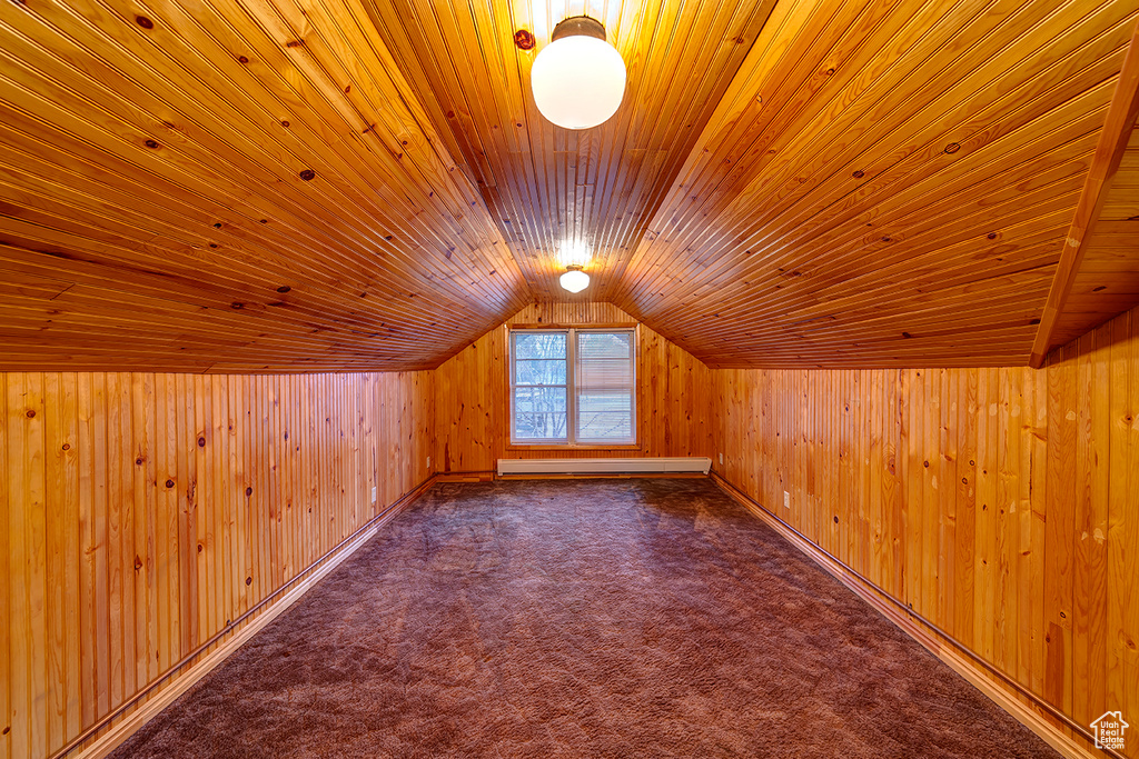 Additional living space featuring wooden walls, baseboard heating, vaulted ceiling, and wooden ceiling