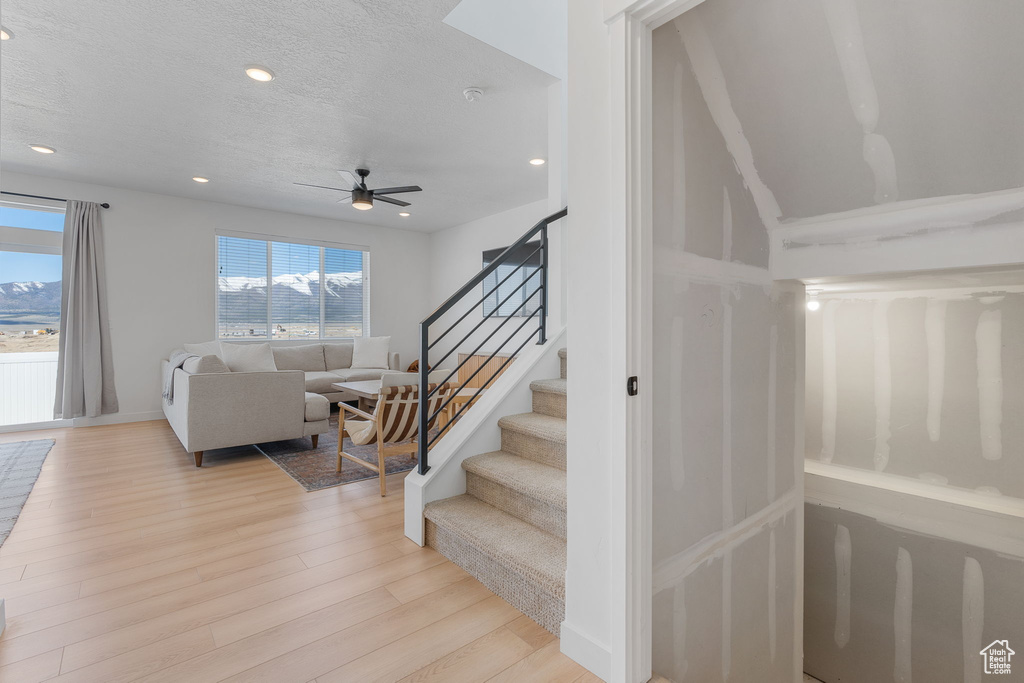 Staircase featuring light hardwood / wood-style floors and ceiling fan