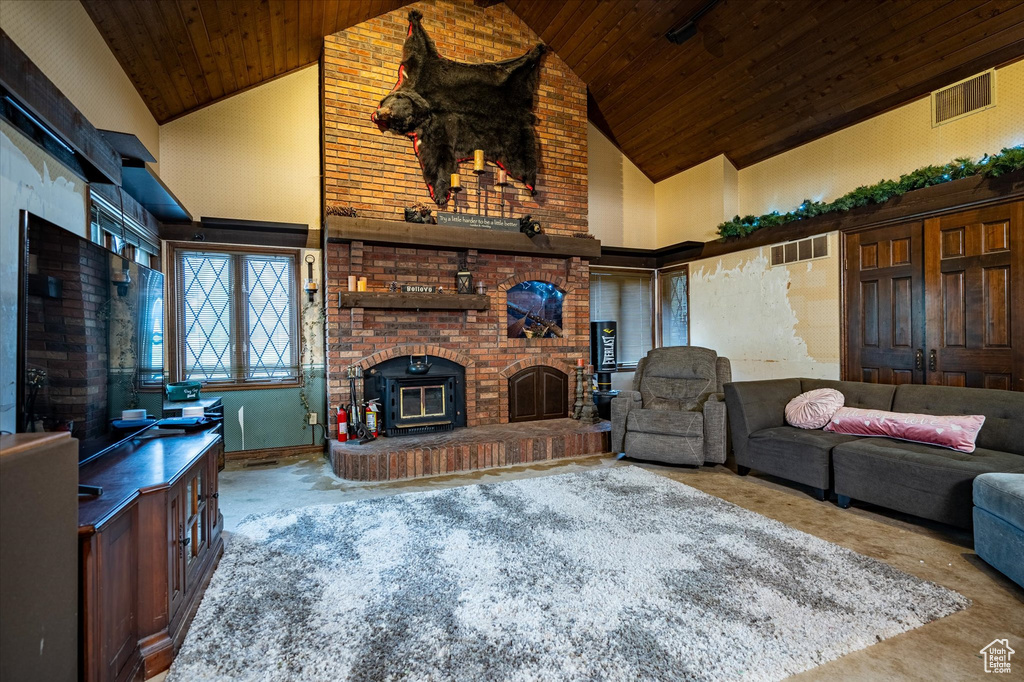 Living room featuring wood ceiling, a brick fireplace, and high vaulted ceiling
