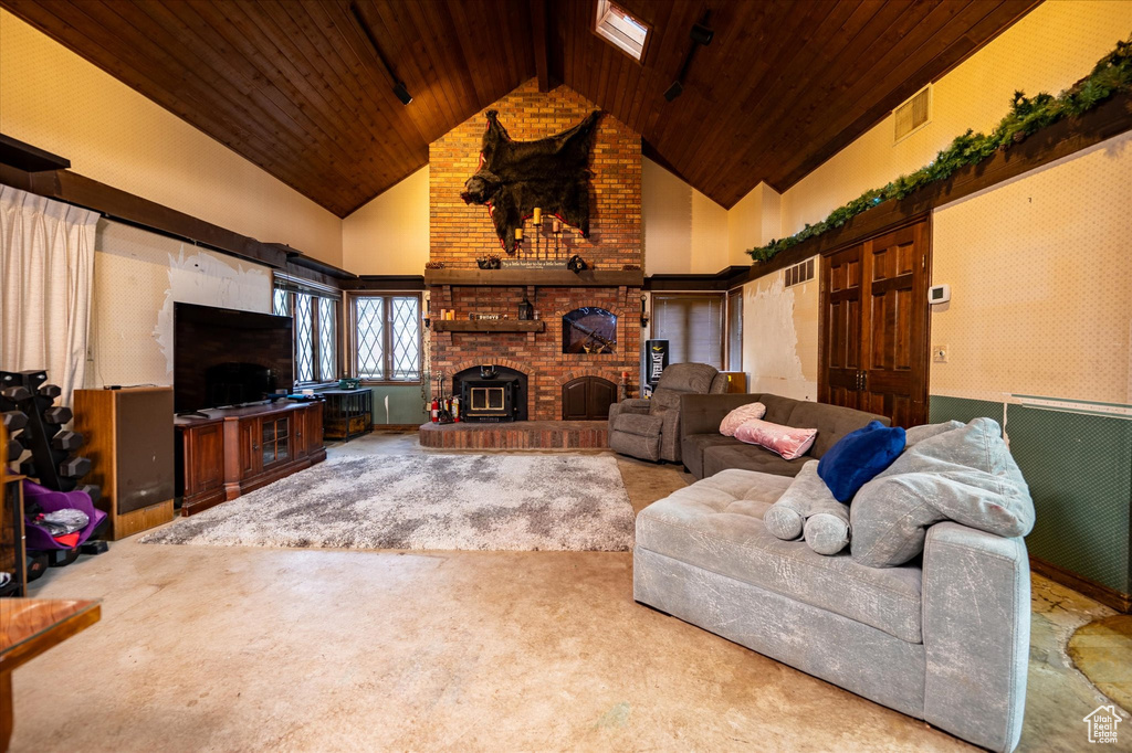 Living room featuring a fireplace, wood ceiling, carpet floors, and high vaulted ceiling