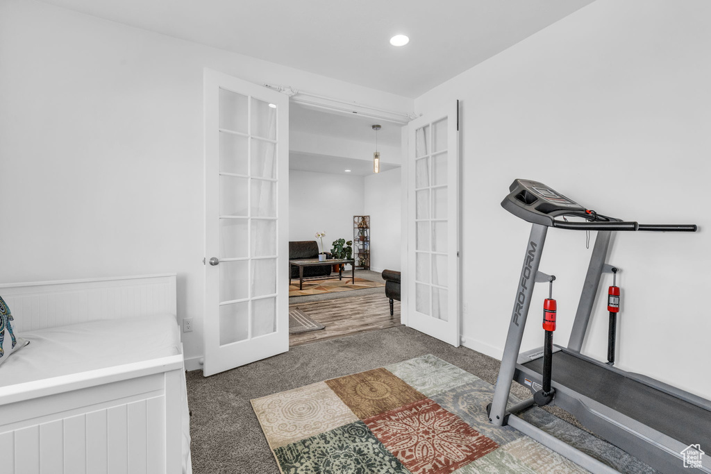 Exercise area with french doors and dark carpet