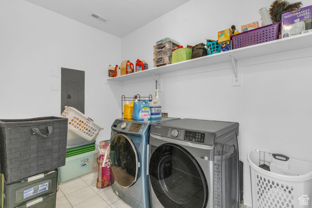 Laundry room featuring light tile flooring and washing machine and clothes dryer