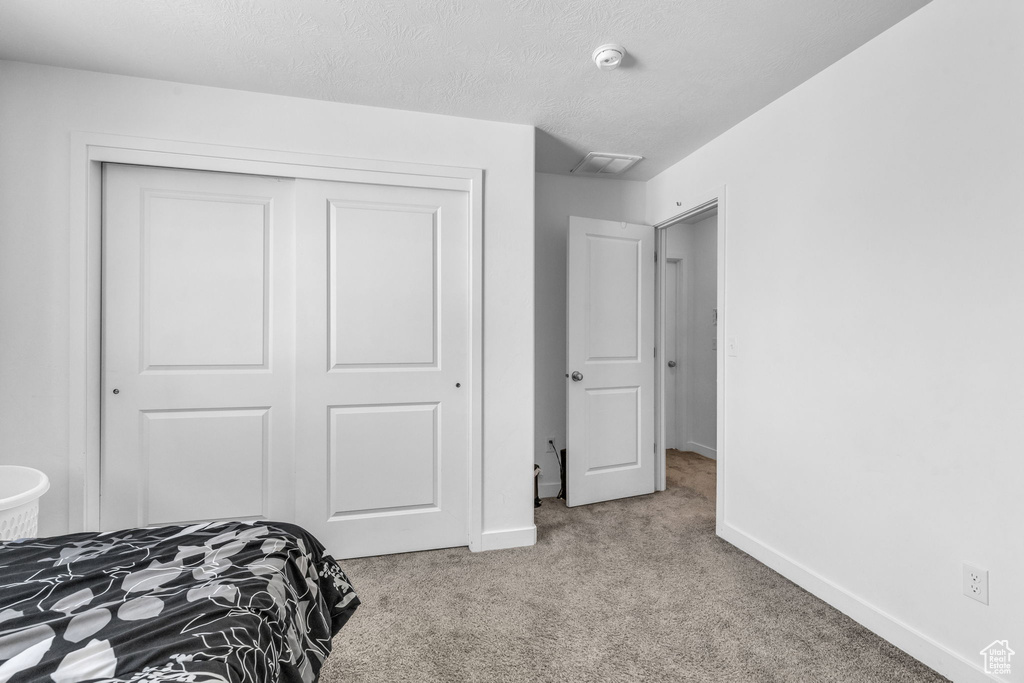 Carpeted bedroom with a closet