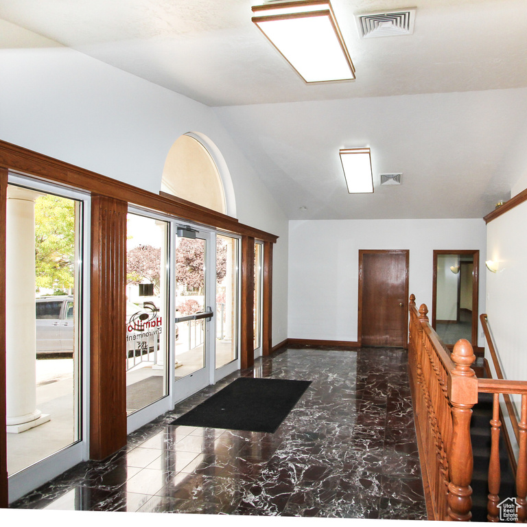 Interior space featuring lofted ceiling and dark tile flooring